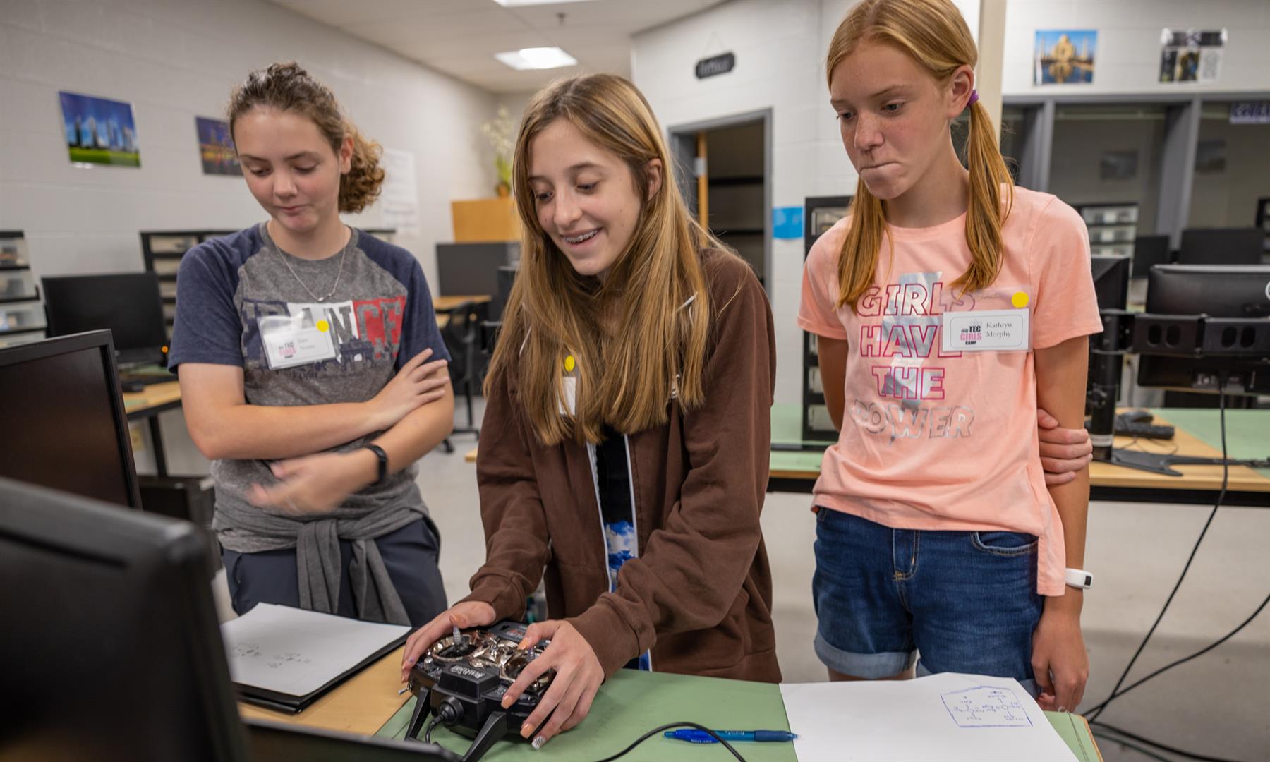 Three girls use a drone simulator